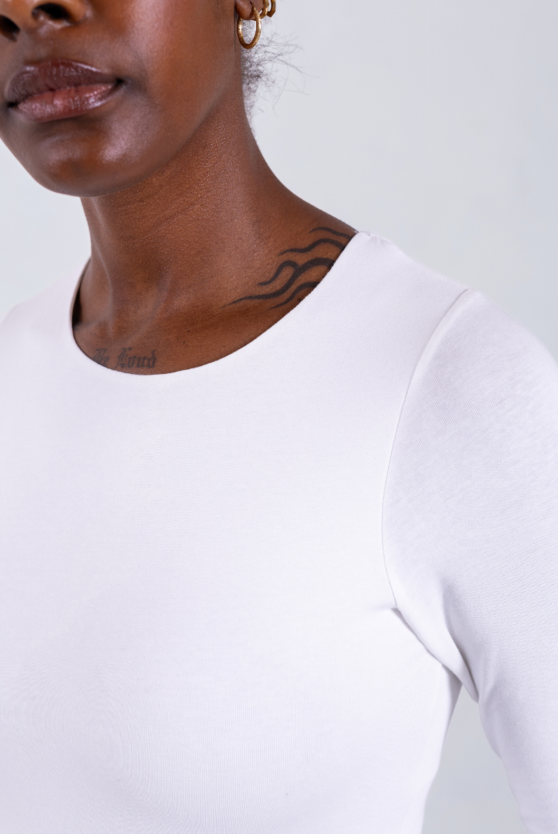 close up of white organic cotton crew neck long sleeve bodysuit