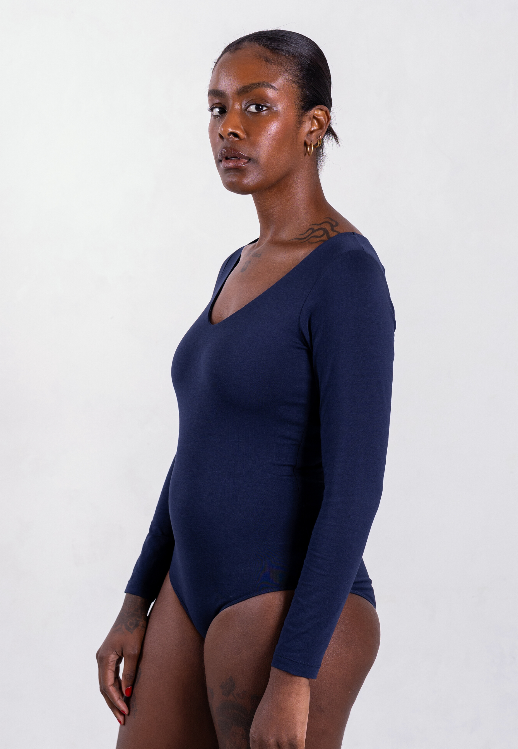 side of navy blue organic cotton v-neck long sleeve bodysuit