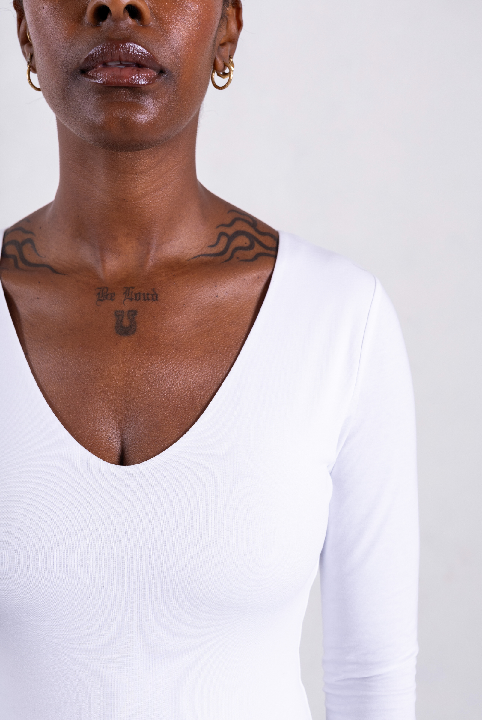 close up of white organic cotton v-neck long sleeve bodysuit