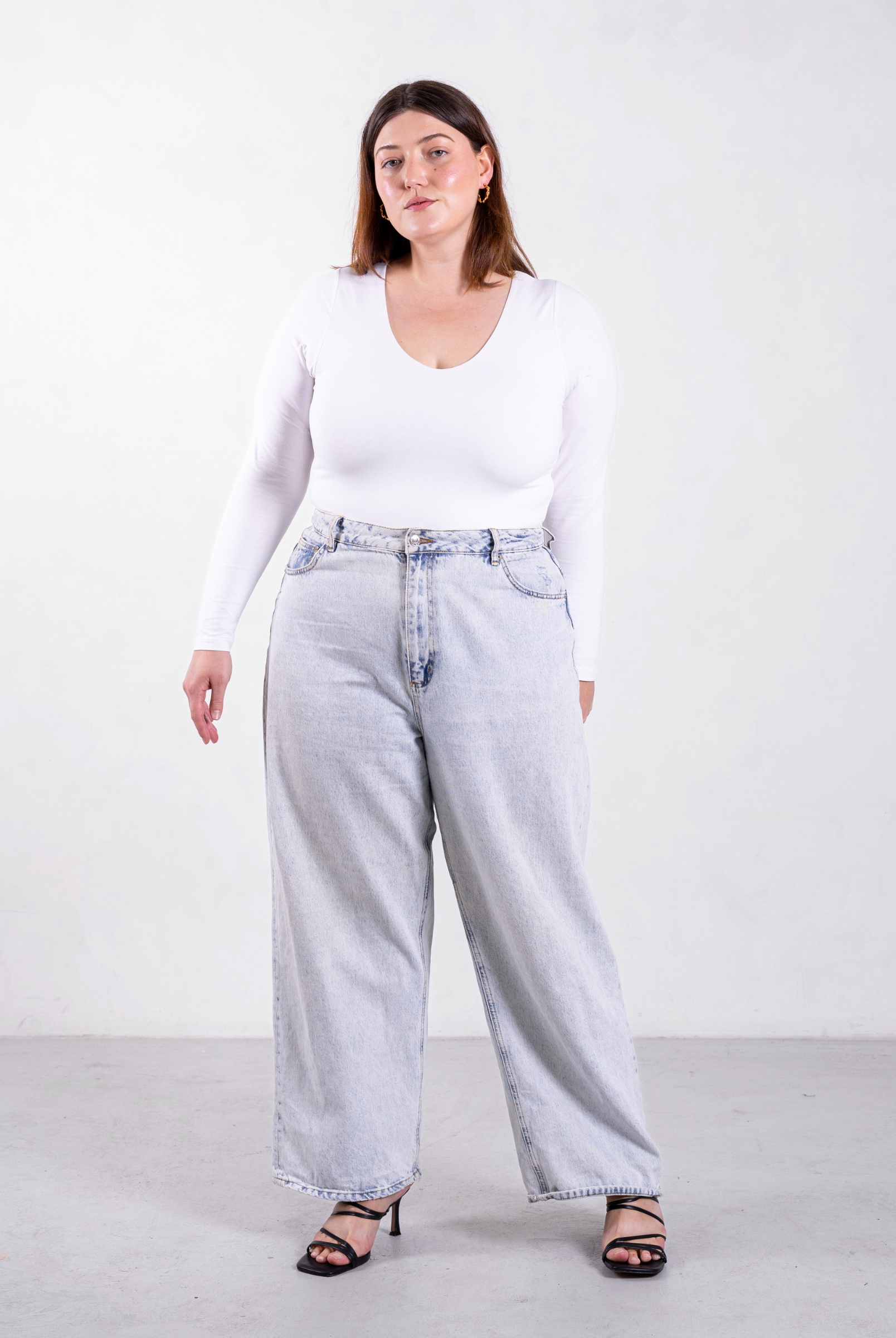 styled image of white organic cotton v-neck long sleeve bodysuit