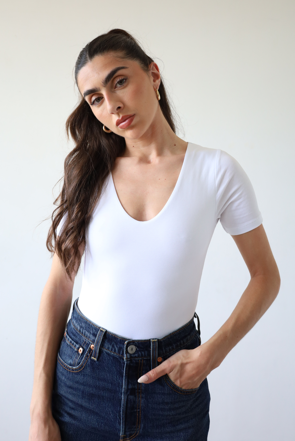 Organic cotton white crew neck short sleeve bodysuit on model, front