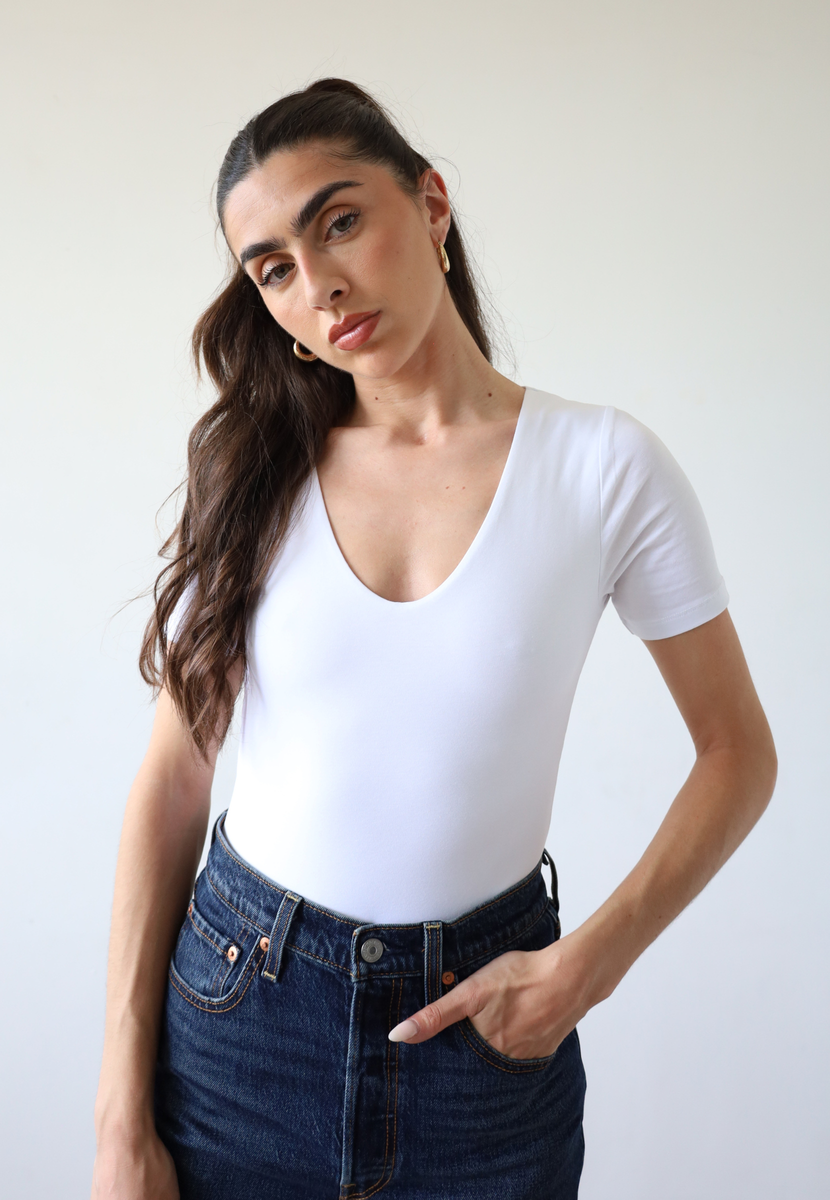 Organic cotton white crew neck short sleeve bodysuit on model, front