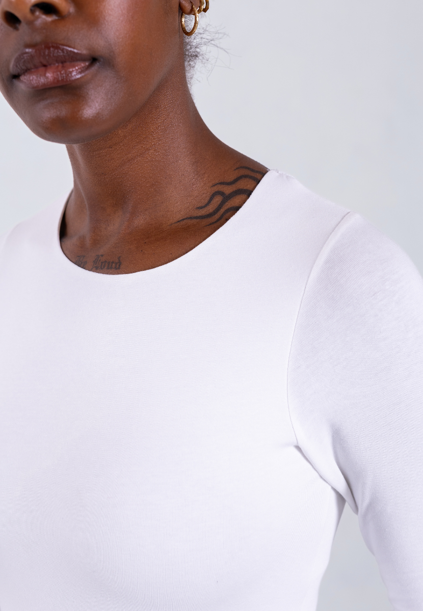 close up of white organic cotton crew neck long sleeve bodysuit