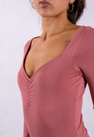 close up of organic cotton long sleeve sweetheart bodysuit rose