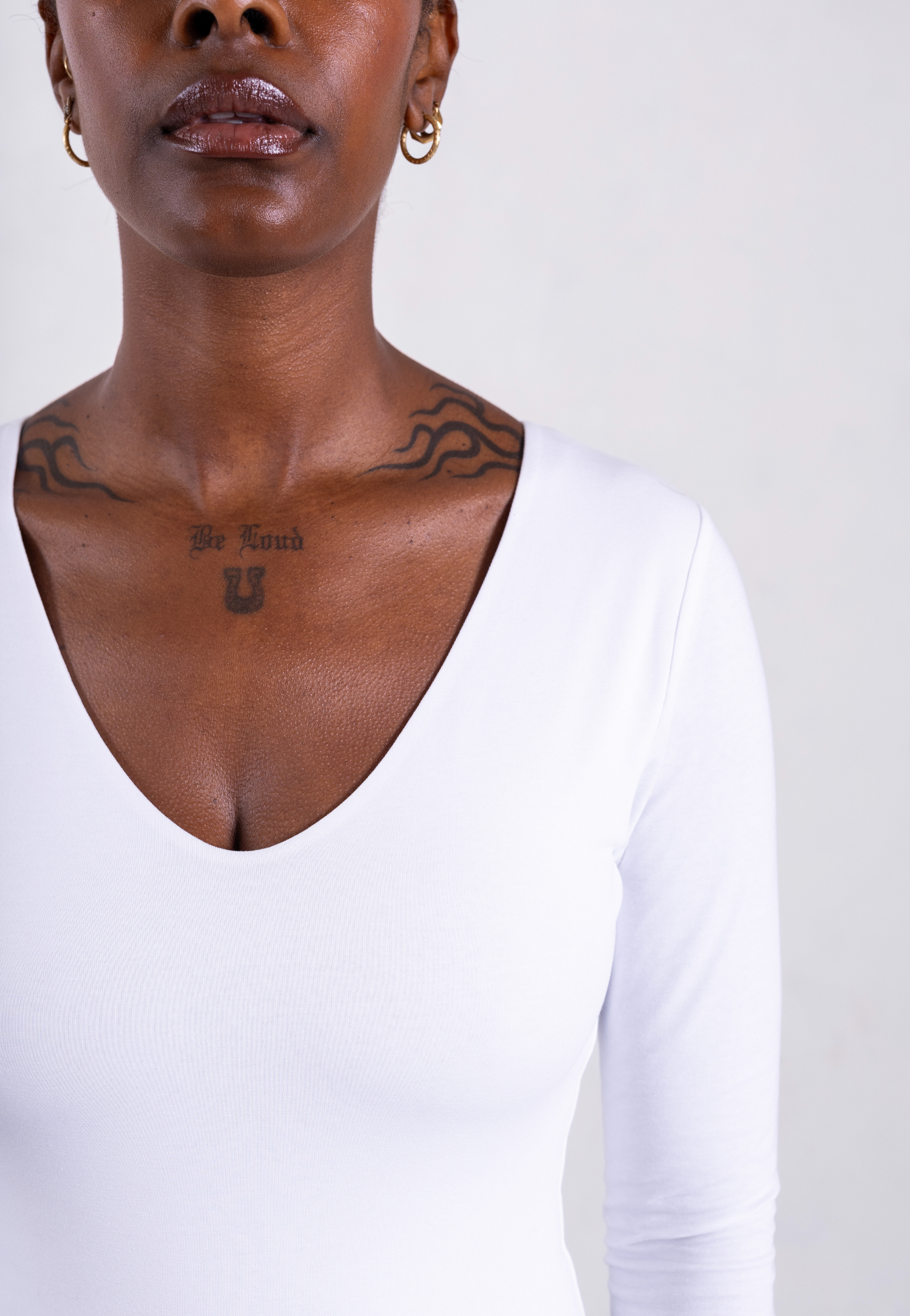close up of white organic cotton v-neck long sleeve bodysuit
