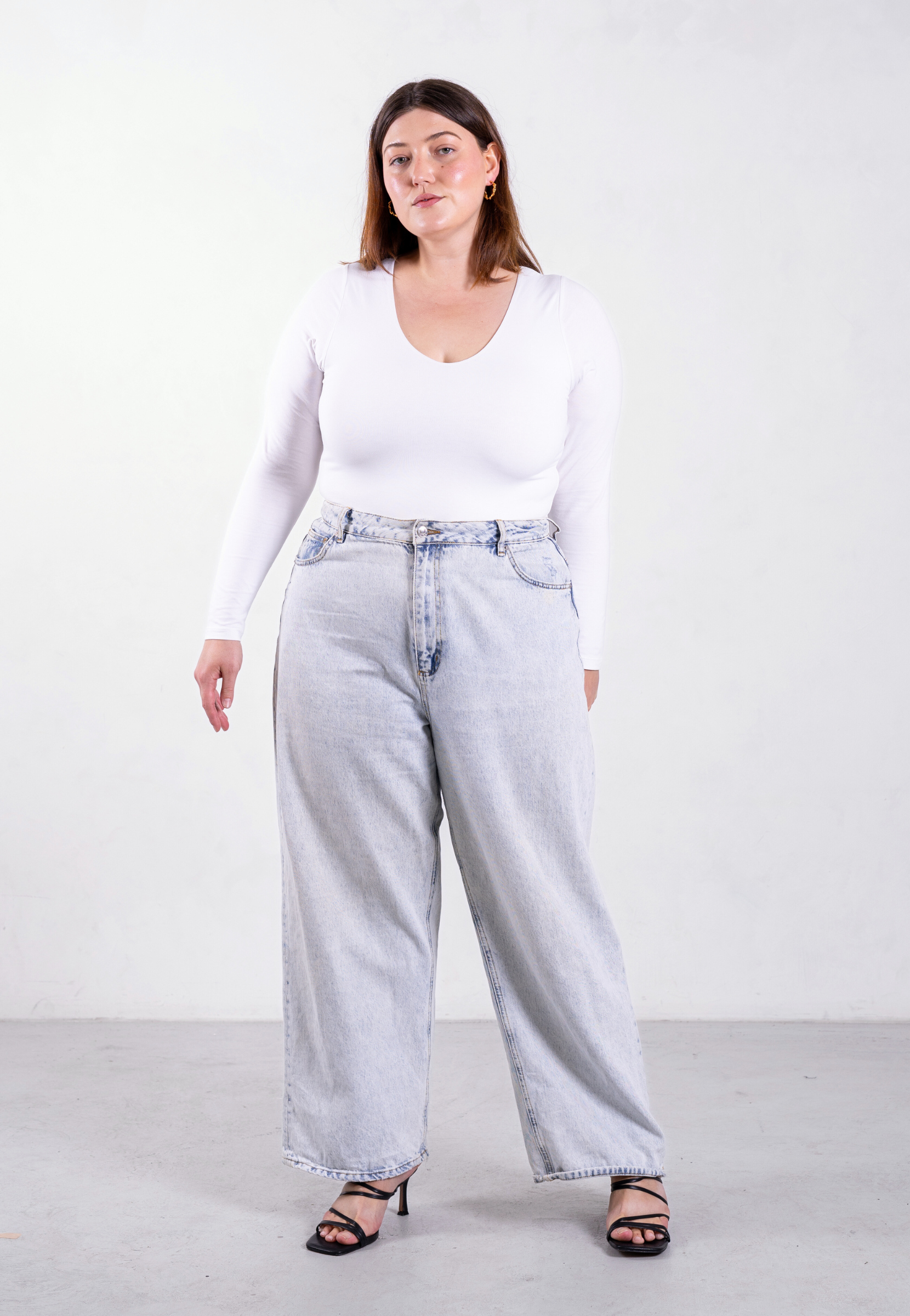 styled image of white organic cotton v-neck long sleeve bodysuit