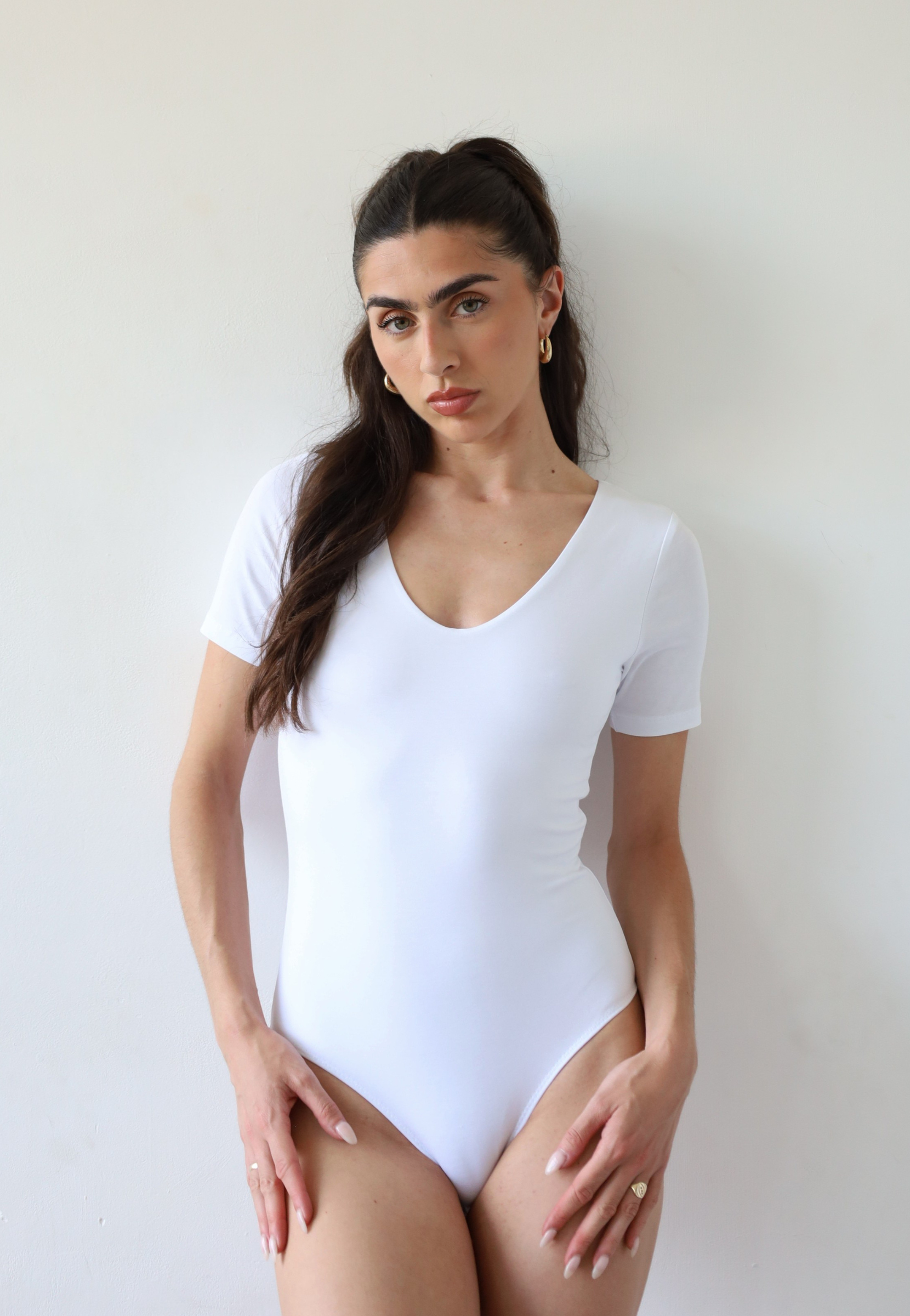 Organic cotton white crew neck short sleeve bodysuit on model, front